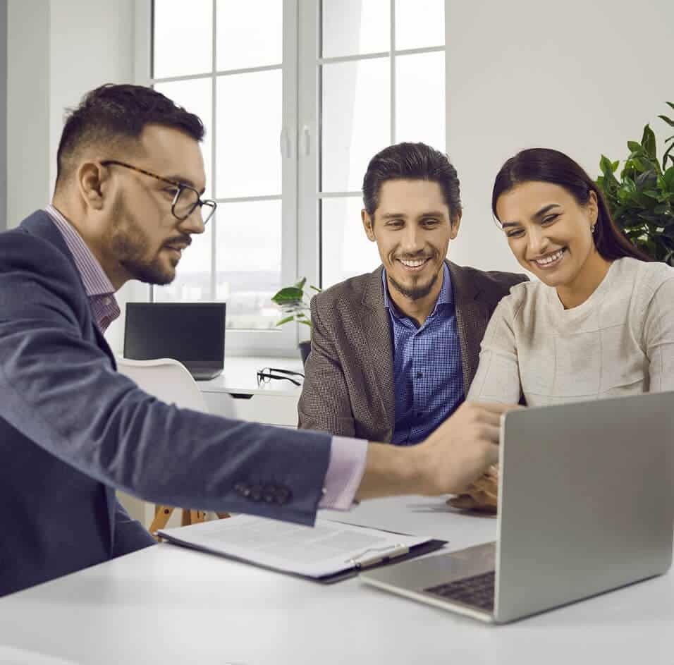 Business meeting with advisor and couple at laptop.