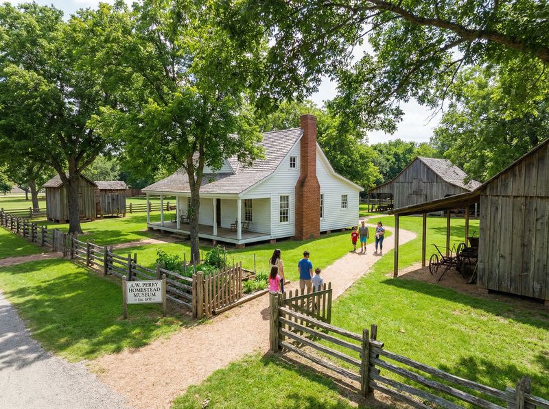 Historic farmhouse with visitors and wooden barns