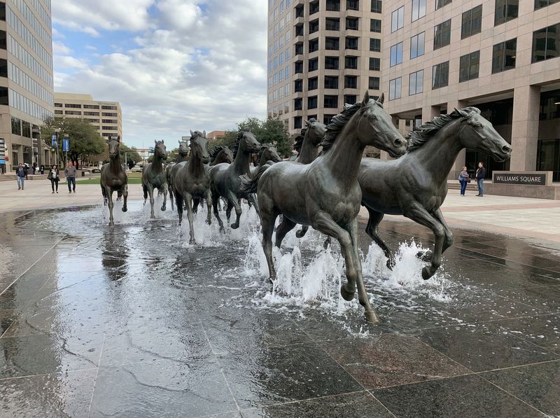 Bronze horse statues galloping through a plaza