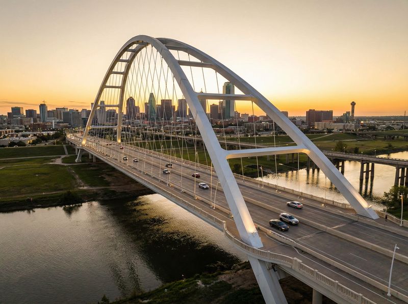Modern bridge with city skyline at sunset