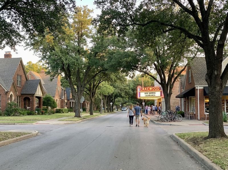 Tree-lined street with vintage movie theater.