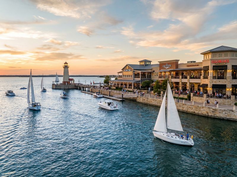 Scenic harbor with boats and lighthouse at sunset